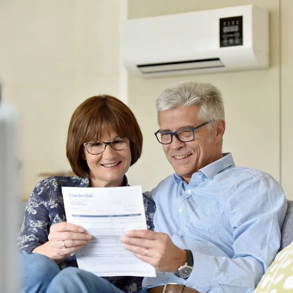 Couple reviewing an energy bill beside a BlizzAir portable air conditioner